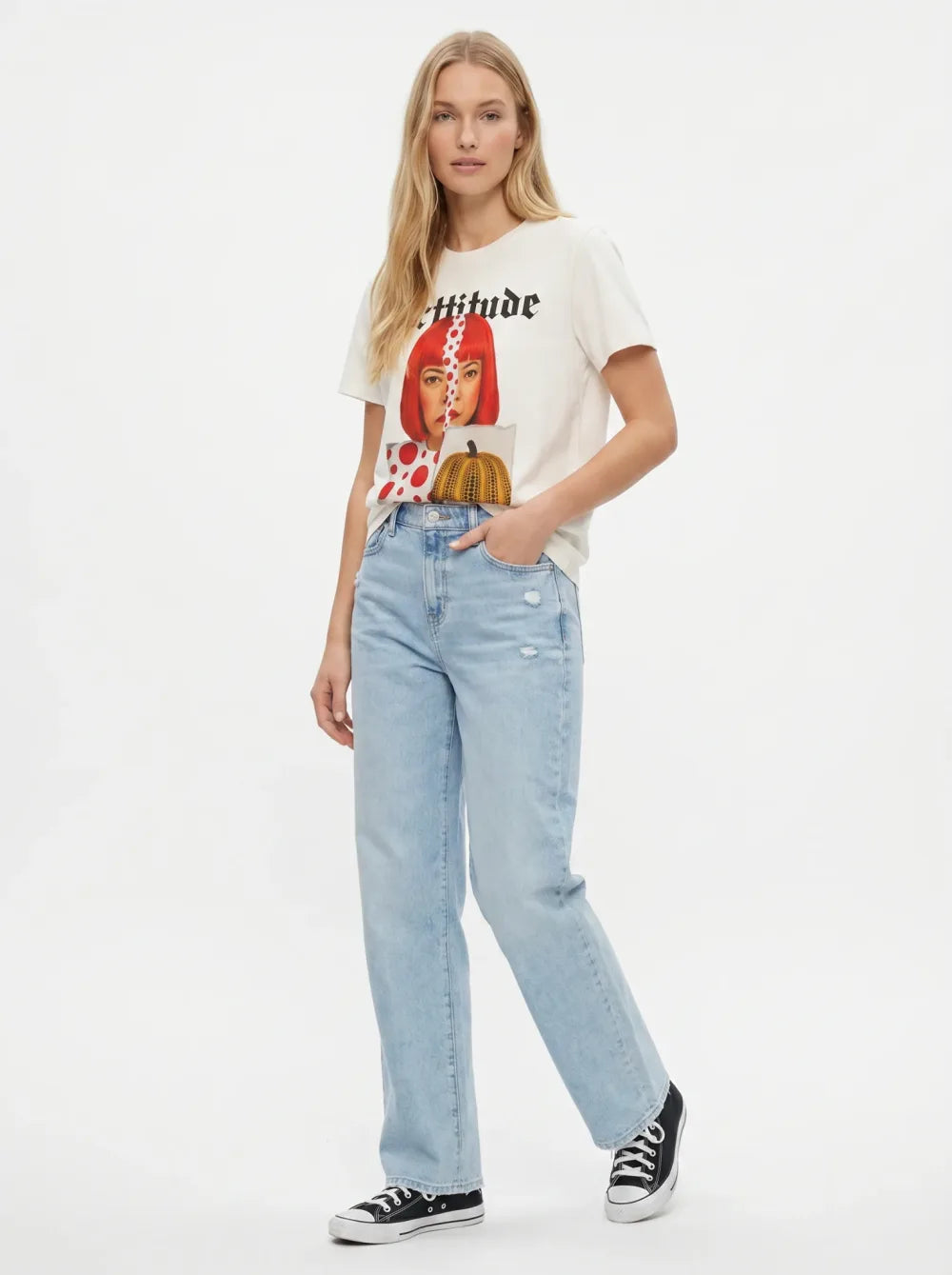 Cream tee with a colour portrait print on a polka-dot ground, distressed jeans, black sneakers