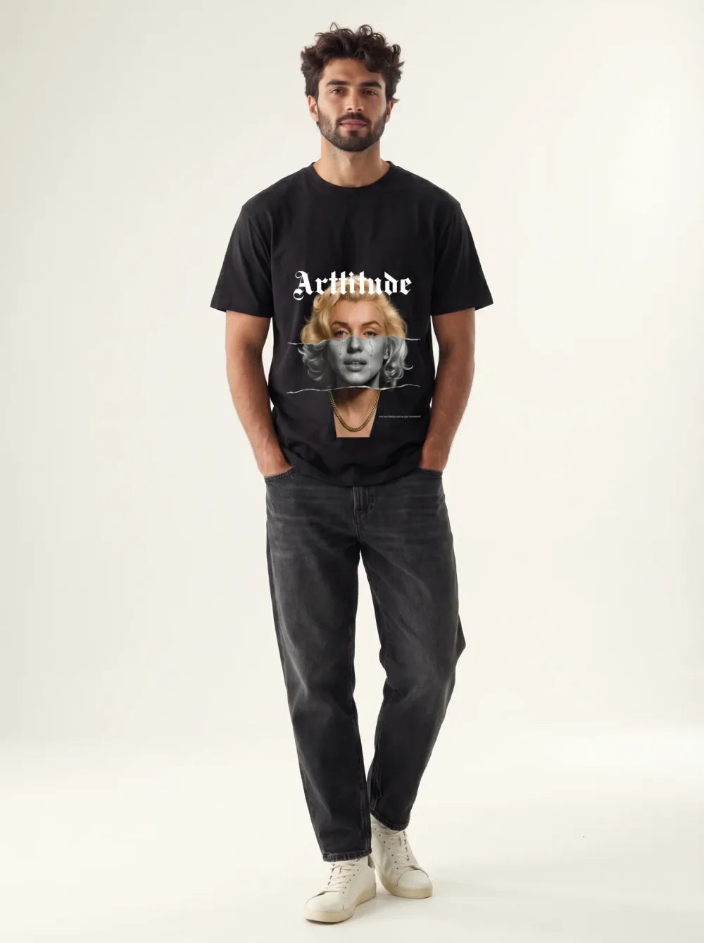 Black tee with a monochrome portrait print, dark straight jeans, cream high-top sneakers, gold chain necklace