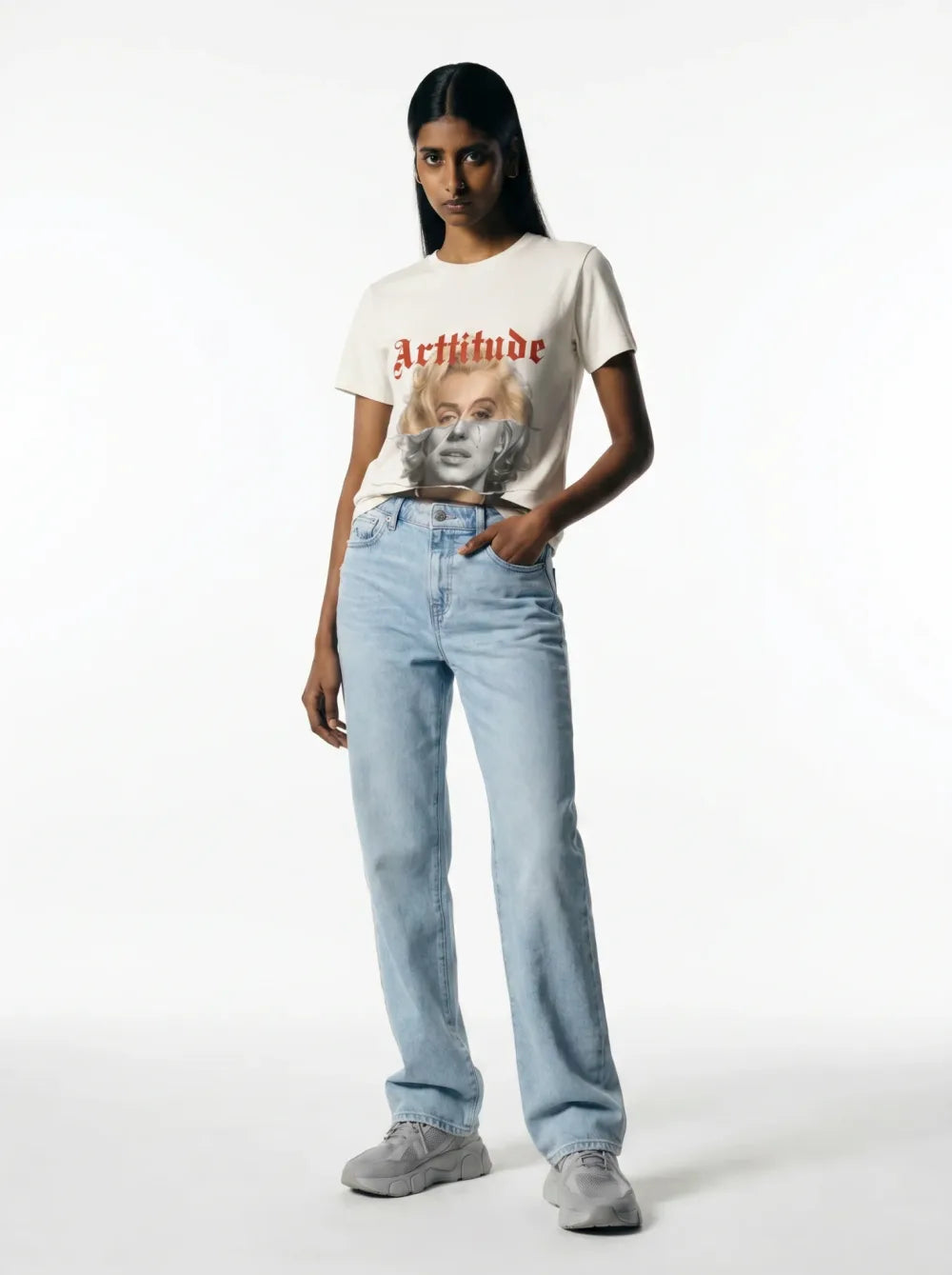 Cropped cream tee with a monochrome portrait print, light-wash straight jeans, grey chunky sneakers